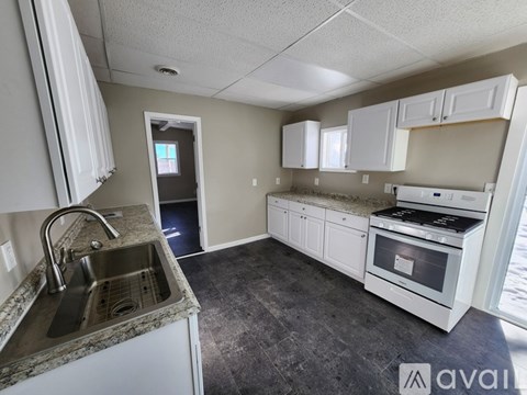 A kitchen with white cabinets and a granite countertop.