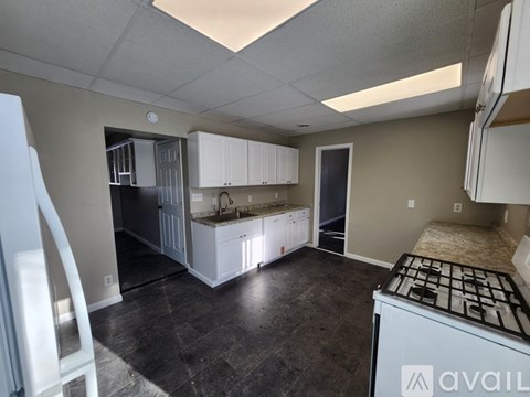 A kitchen with a refrigerator, sink, and cabinets is available for rent.