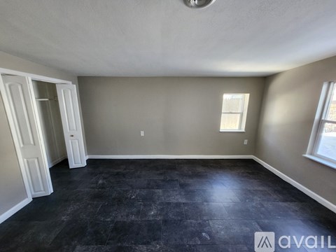 A room with a grey wall and a black floor.