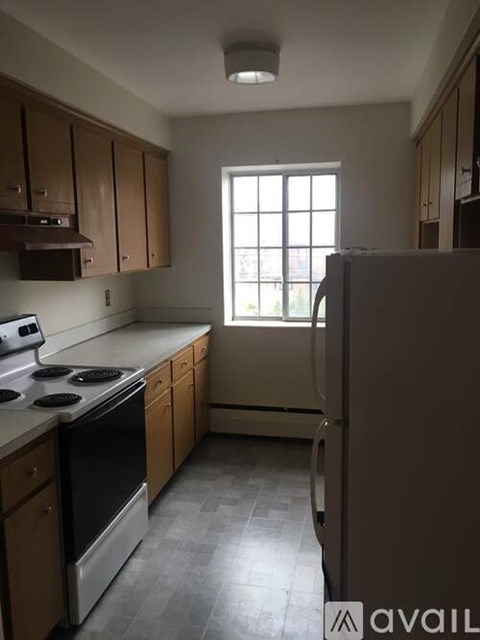 A kitchen with wooden cabinets and a stove top oven.