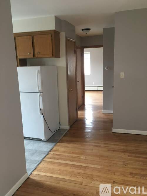 A kitchen with a white fridge and wooden cabinets.
