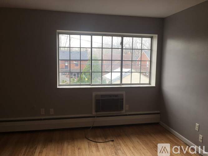 A room with a window and a fireplace is available for rent.