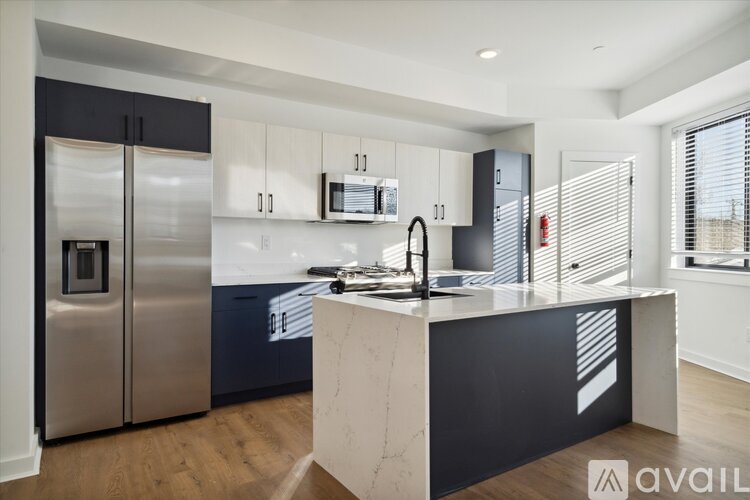 A modern kitchen with a marble island and stainless steel appliances.