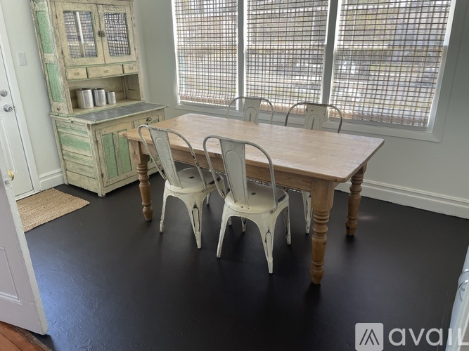 A dining room with a wooden table and chairs.