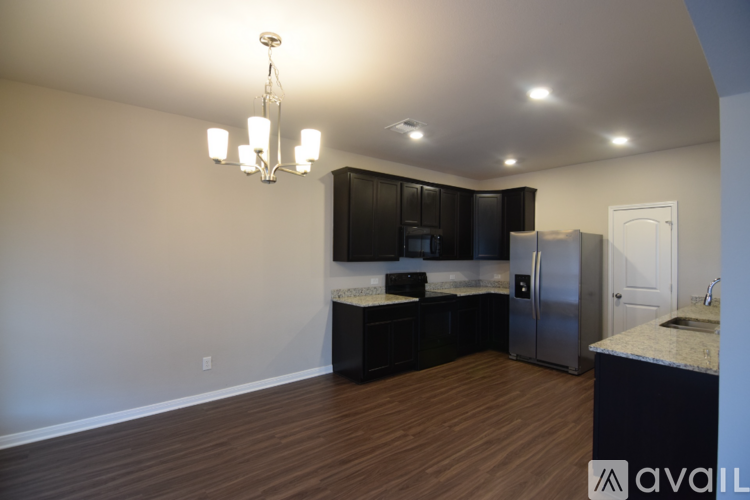A kitchen with a refrigerator, sink, and cabinets.