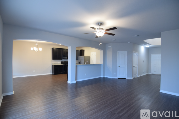 A spacious room with a ceiling fan and wooden flooring.