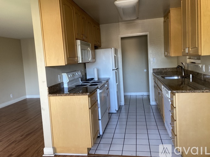 A kitchen with wooden cabinets and a white refrigerator.