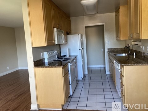 A kitchen with wooden cabinets and a white refrigerator.
