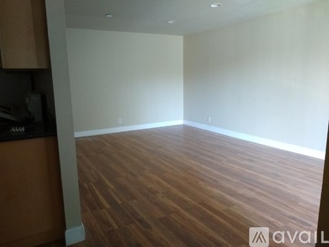 A room with wooden flooring and white walls.