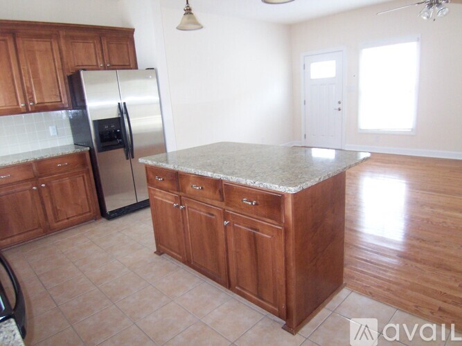 A kitchen with wooden cabinets and a granite countertop.
