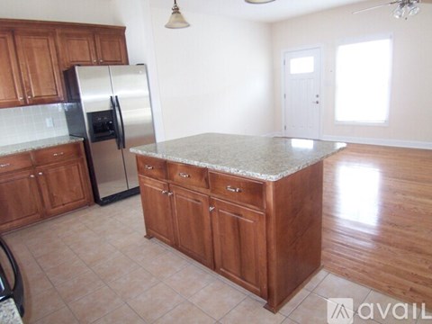 A kitchen with wooden cabinets and a granite countertop.
