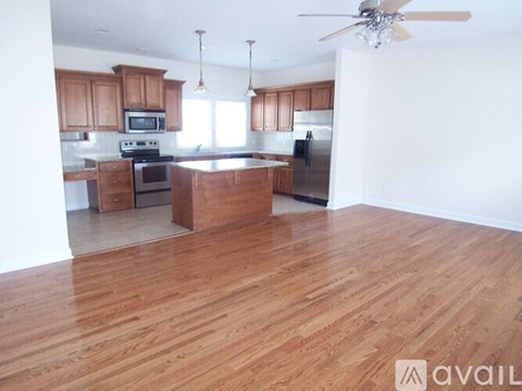 A kitchen with wooden cabinets and a wooden floor.