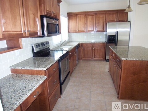 A kitchen with wooden cabinets and granite countertops.