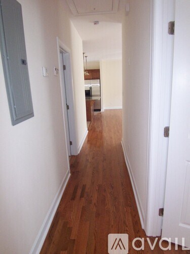 A hallway with wood floors and white walls.