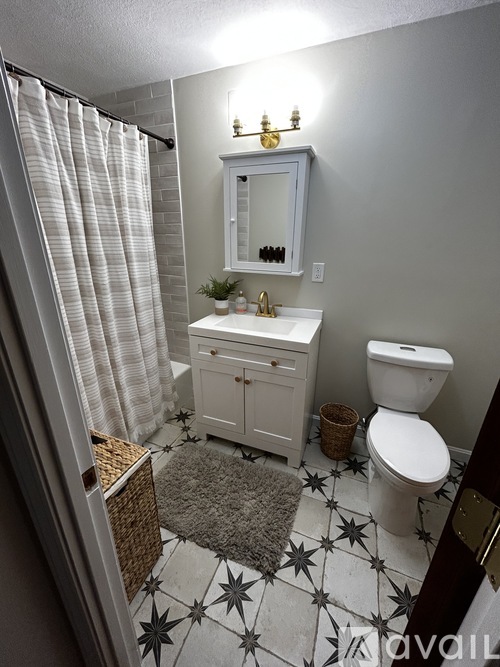 A bathroom with a toilet, sink, and shower.