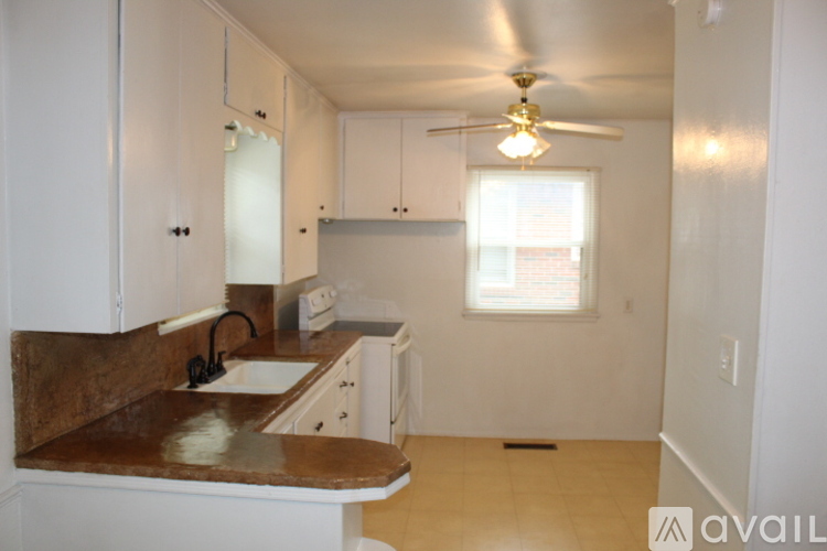 A kitchen with white cabinets and a brown counter top.