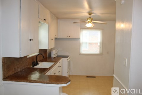 A kitchen with white cabinets and a brown counter top.