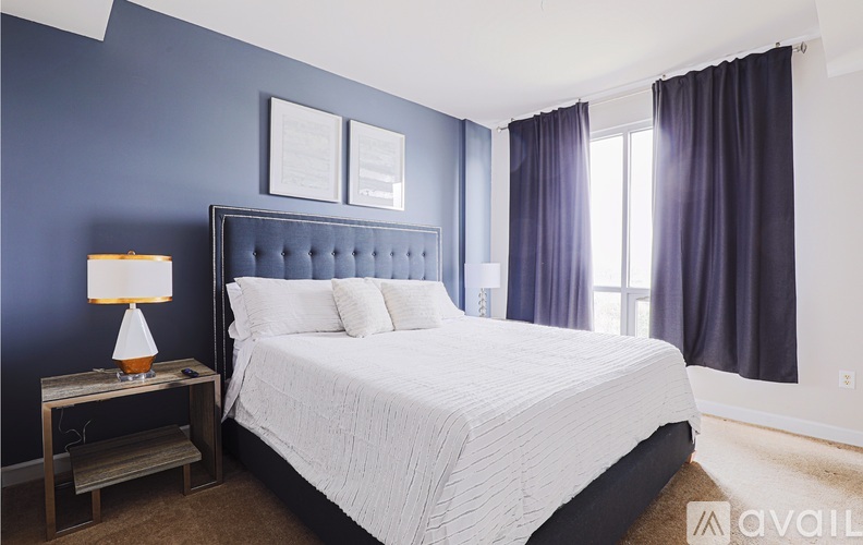 A bedroom with a white bed and a blue wall.