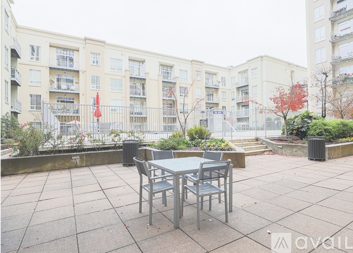 A patio with a table and chairs in front of apartment buildings.