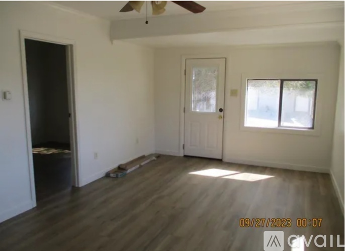 A room with a ceiling fan and a window with blinds.