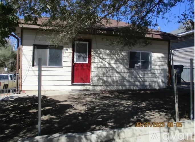 A small white house with a red door is shown in the image.