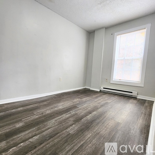 A room with wooden flooring and a window.