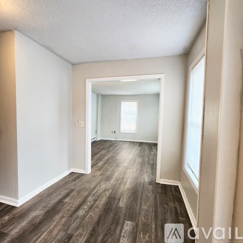 A room with wooden flooring and white walls.