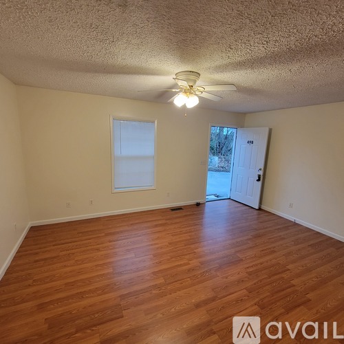 A room with wooden floors and a ceiling fan.