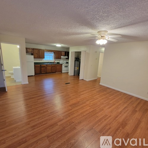 A room with wooden flooring and a ceiling fan.