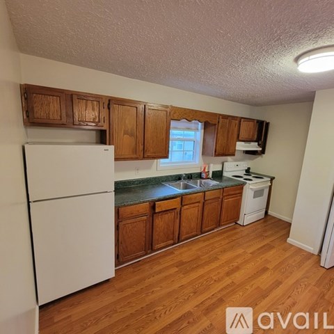A kitchen with wooden cabinets and white appliances.