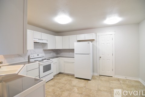 A kitchen with white appliances and cabinets.