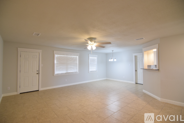 A spacious room with a ceiling fan and tiled flooring.