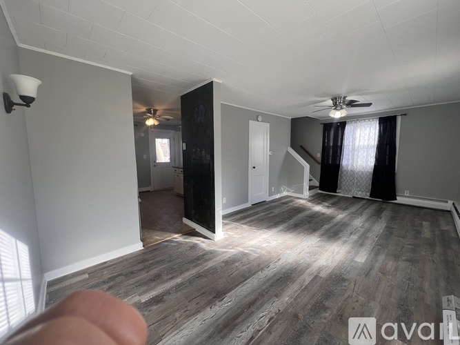 A room with wooden flooring and a ceiling fan.