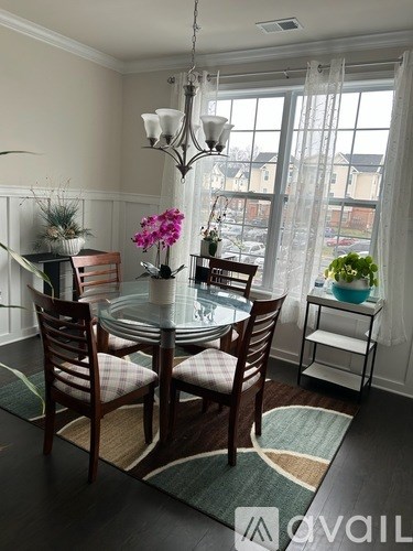 A dining room with a table set for four and a view of the outside.