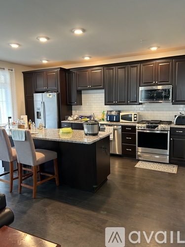 A kitchen with dark brown cabinets and a white backsplash.