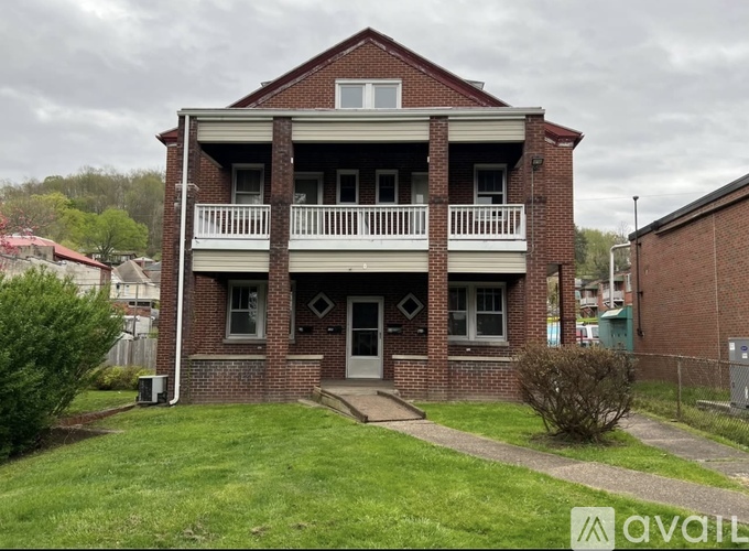 A red brick house with a white porch.