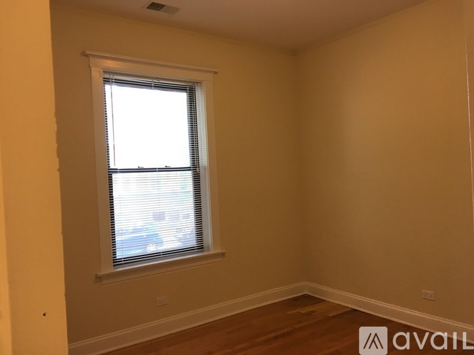 A room with a window and wooden flooring.