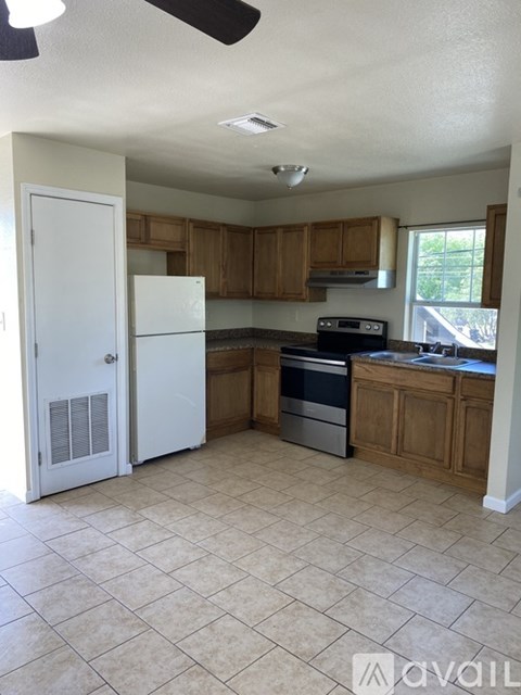 A kitchen with a white refrigerator and wooden cabinets.