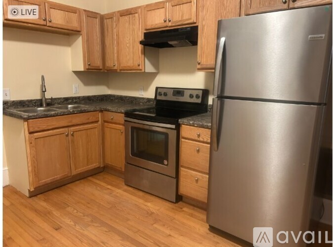 A kitchen with wooden cabinets and a stainless steel refrigerator.
