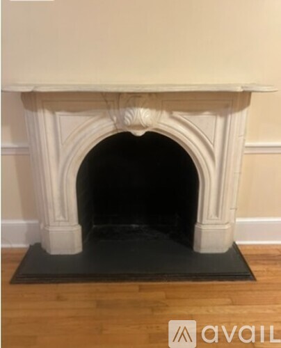 A fireplace with a black mat in front of it.
