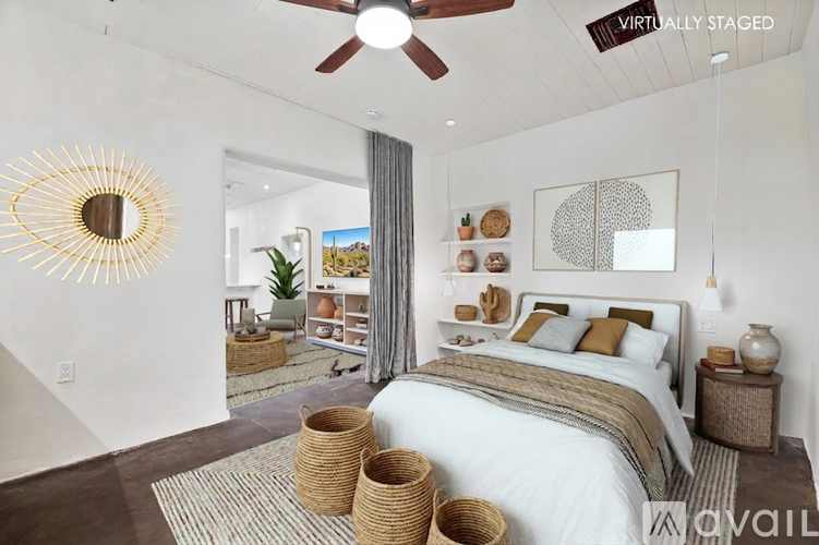 A bedroom with a large bed and a ceiling fan.