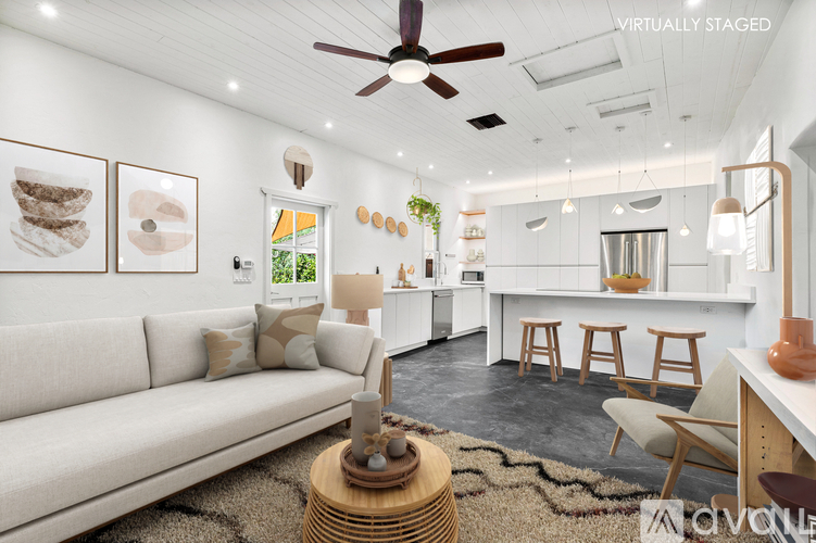 A living room with a white couch and a wooden coffee table.