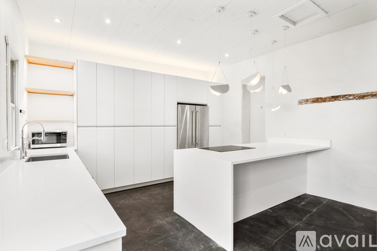 A modern kitchen with white cabinets and a white island.