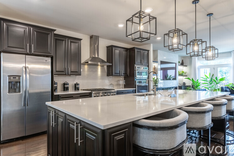 A modern kitchen with a large island and stainless steel appliances.