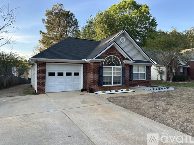 A house with a white garage door and brick exterior.