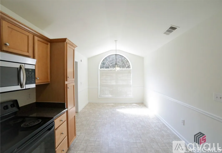 A kitchen with wooden cabinets and a black stove top oven.