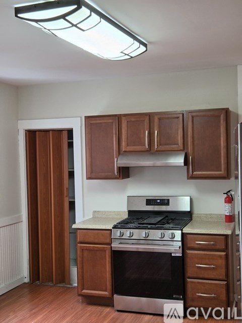 A kitchen with wooden cabinets and a stove top oven.