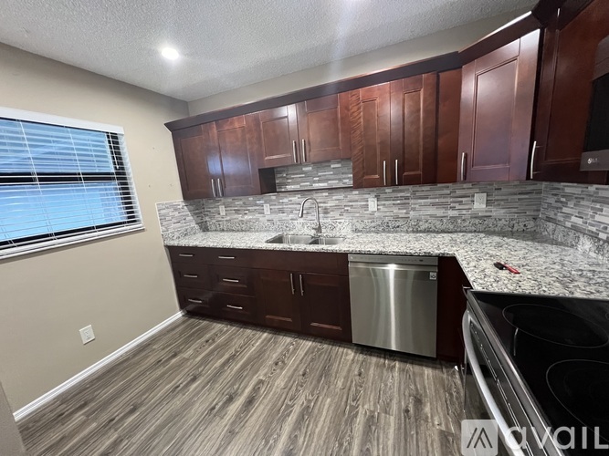 A kitchen with wooden cabinets and a granite countertop.