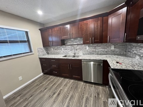 A kitchen with wooden cabinets and a granite countertop.