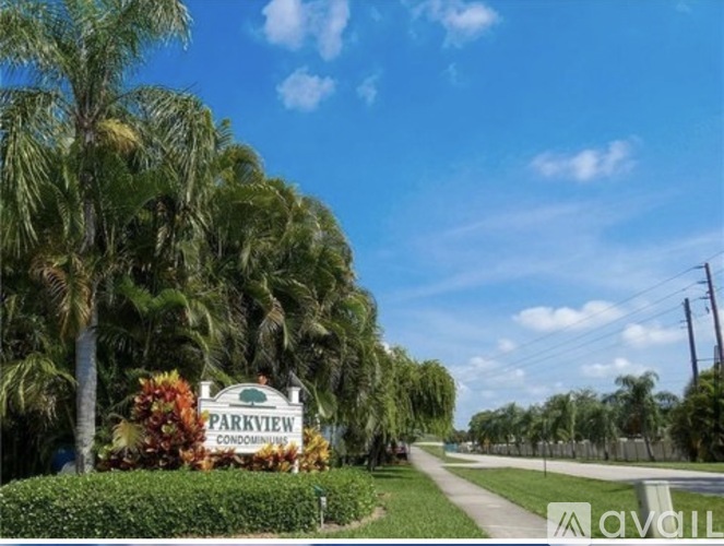 A sign that says Parkview Condos in front of some trees.